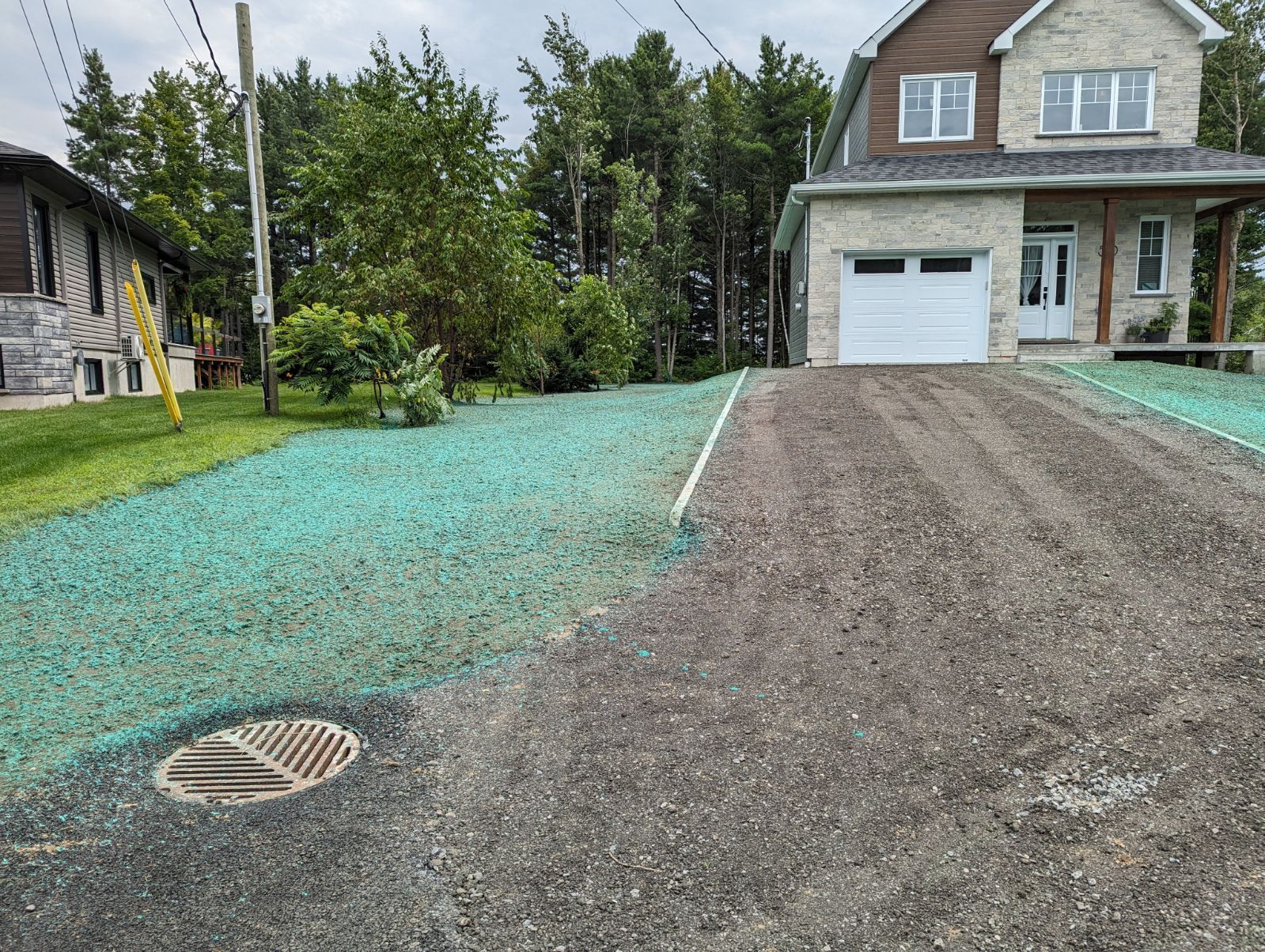 Une maison avec un garage et une allée entourée d'herbe verte.