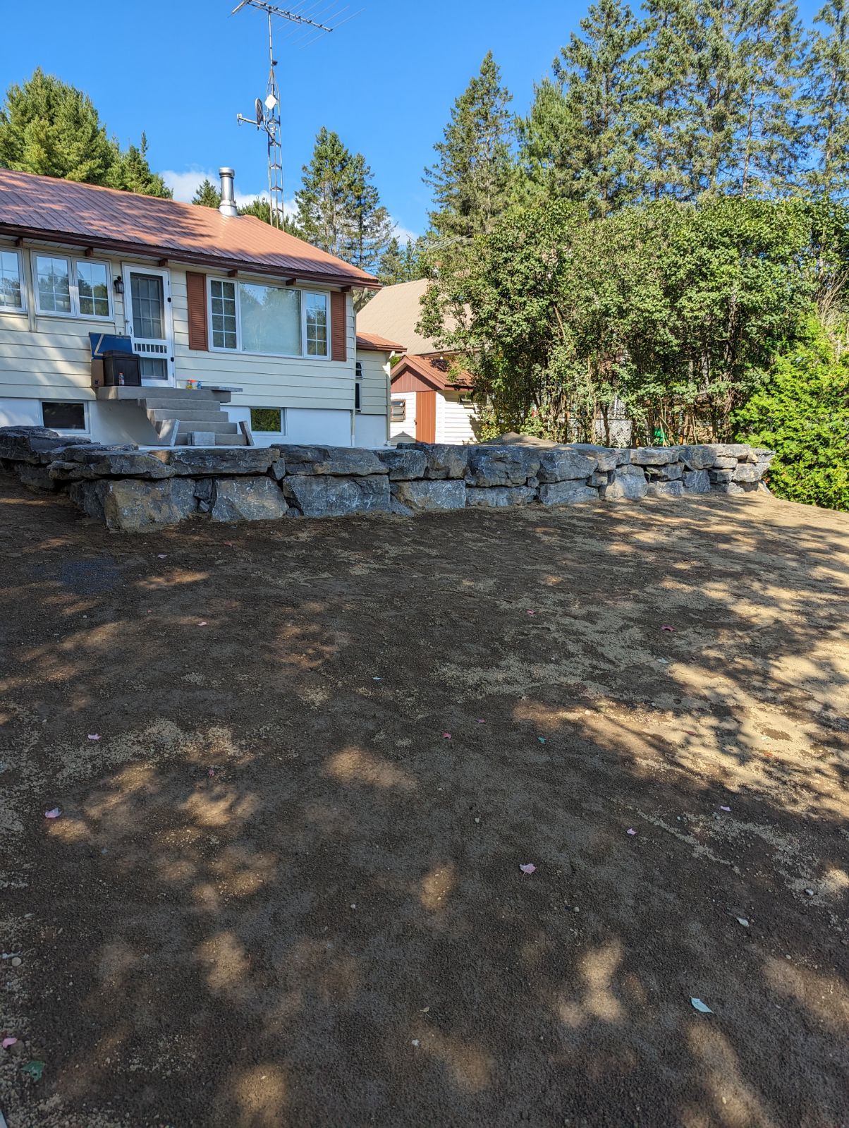 Une maison avec beaucoup de terre devant.