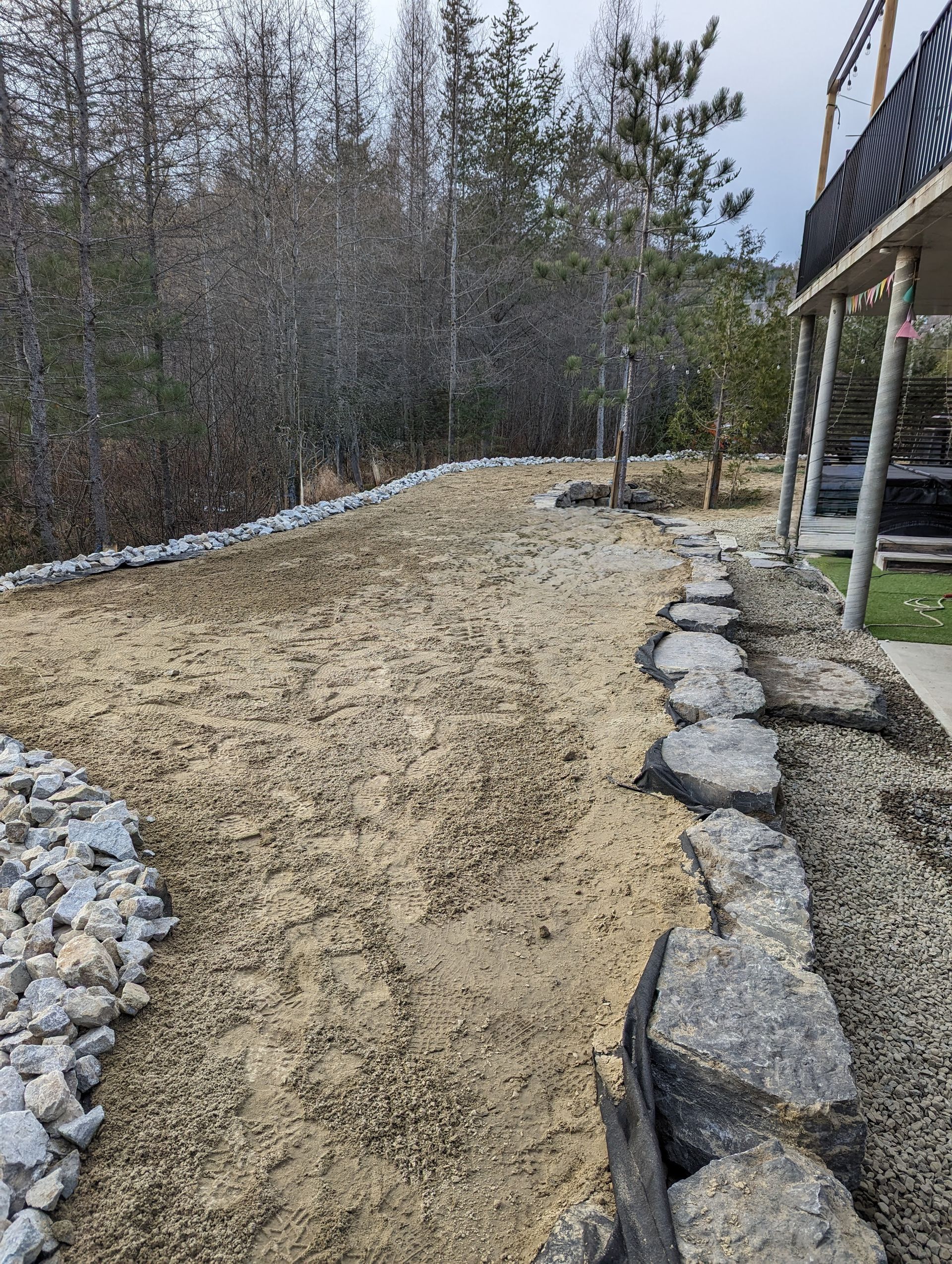 Un chemin de terre menant à une maison avec des arbres en arrière-plan.