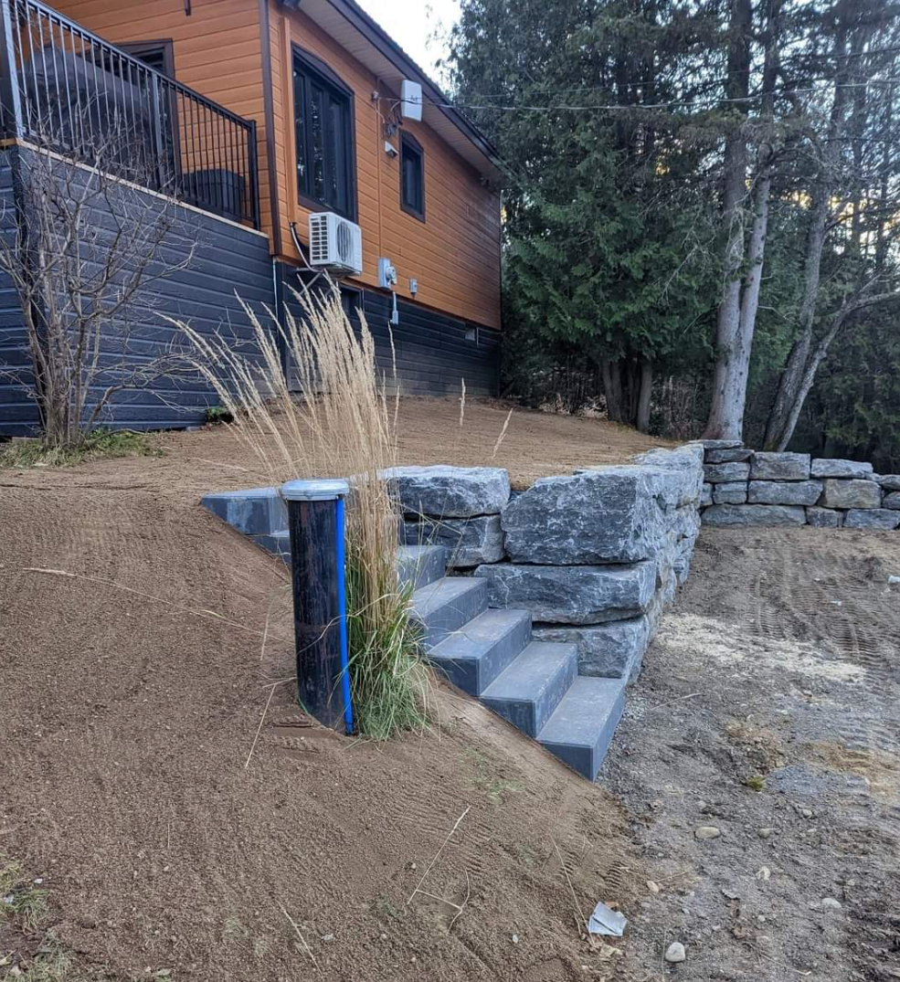 Une maison est située au sommet d'une colline avec des escaliers qui y mènent.
