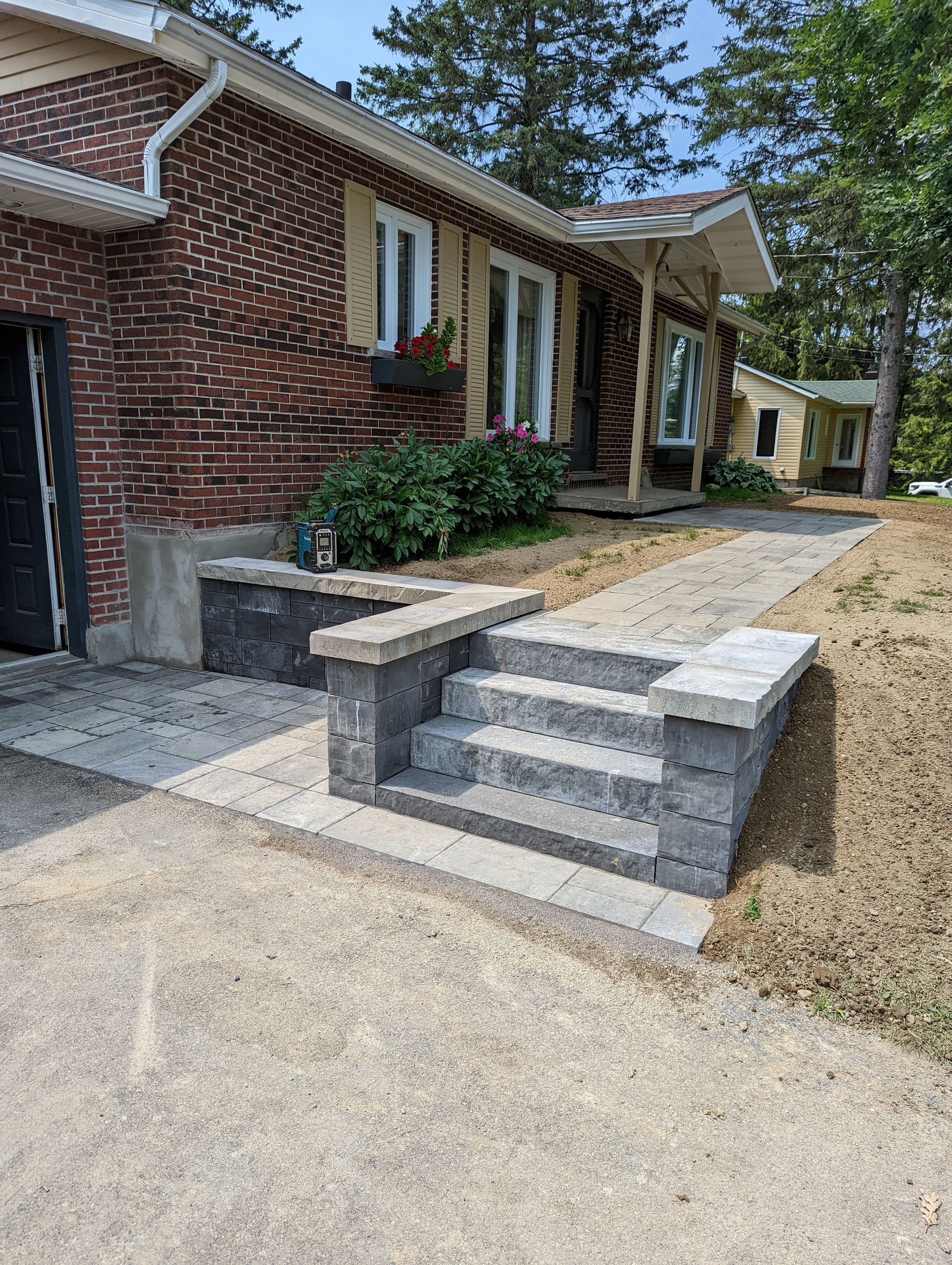 Une maison en brique avec des escaliers menant à la porte d'entrée.