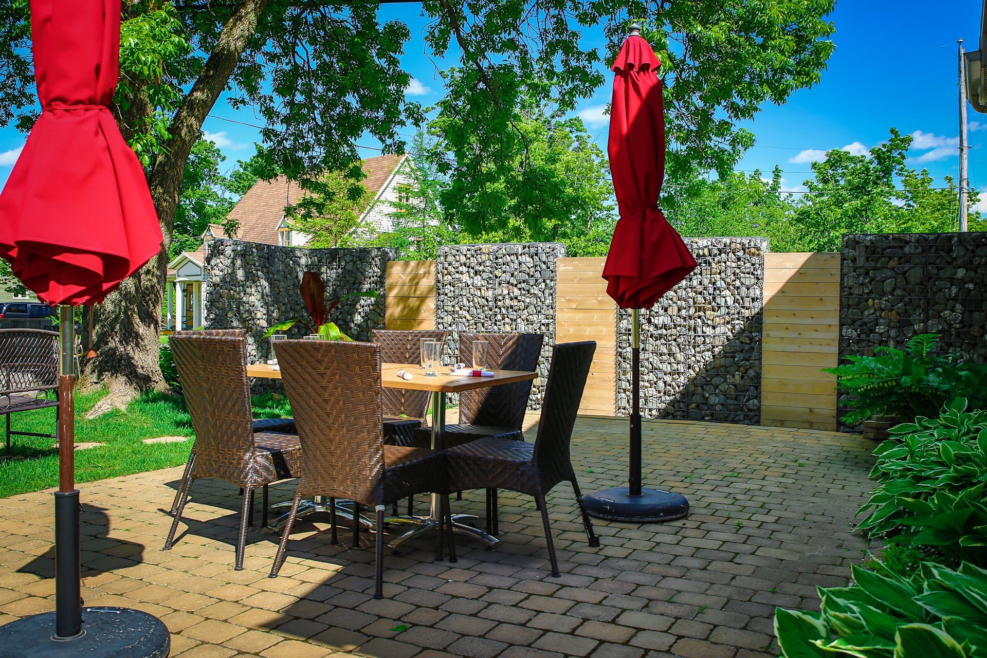 Un patio avec une table et des chaises et des parasols rouges