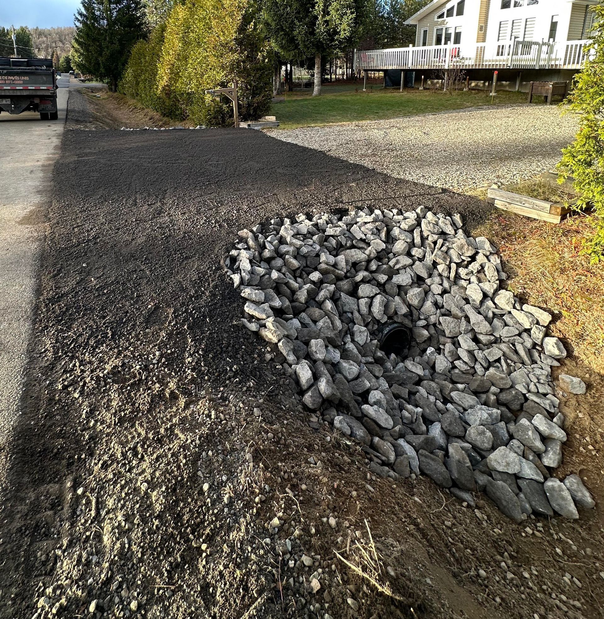 Un camion est garé sur le bord de la route à côté d'un tas de pierres.