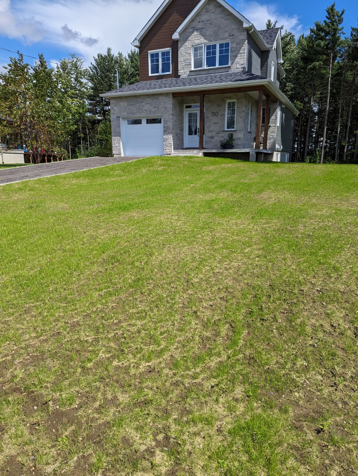 Une grande maison avec une grande pelouse devant.