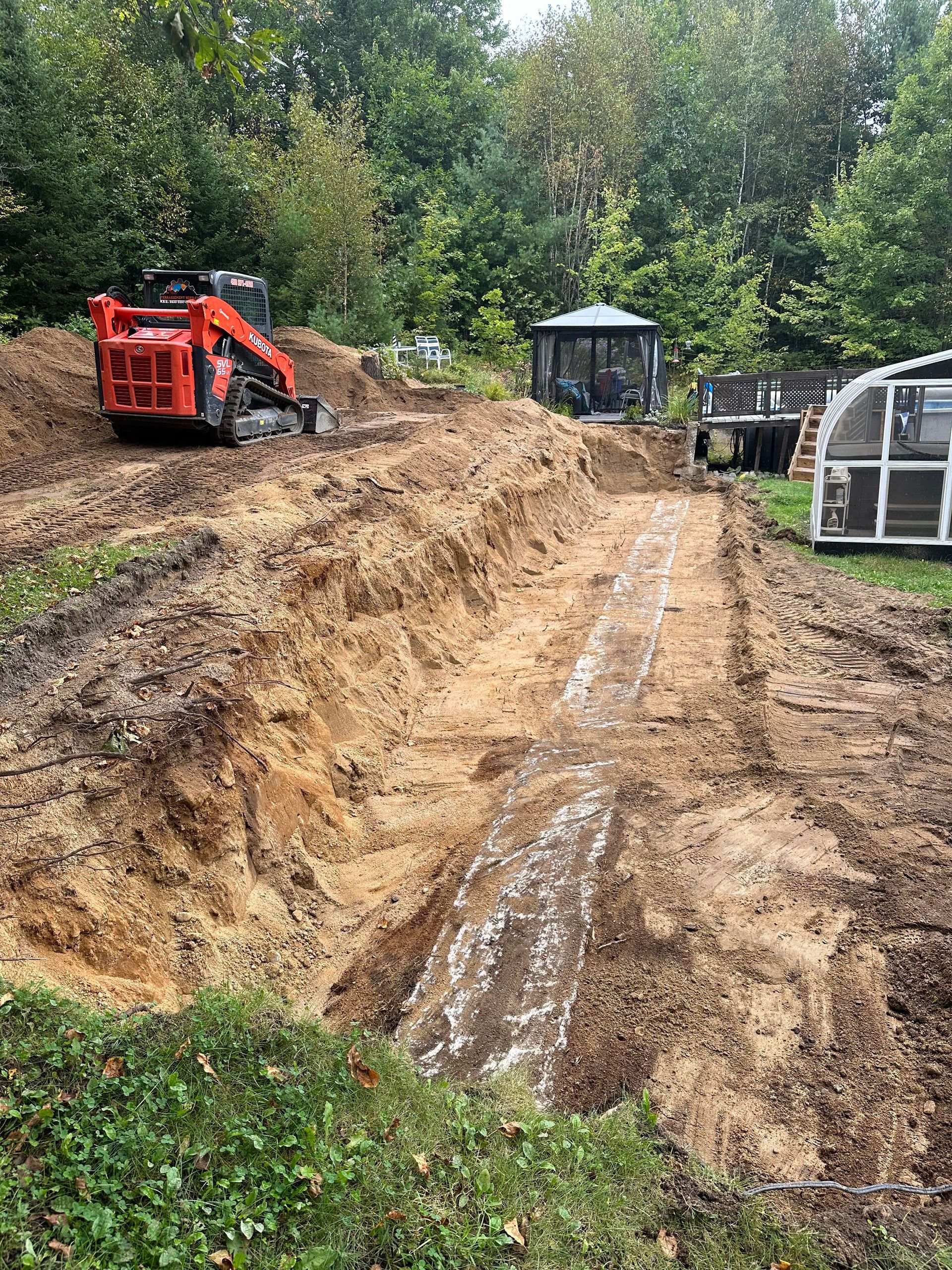 Un bulldozer creuse un trou dans la terre dans une cour.