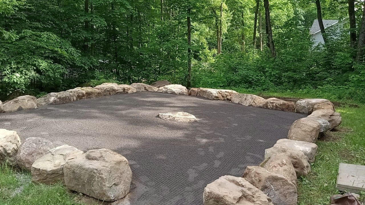 Un cercle de rochers et de graviers au milieu d'une forêt.