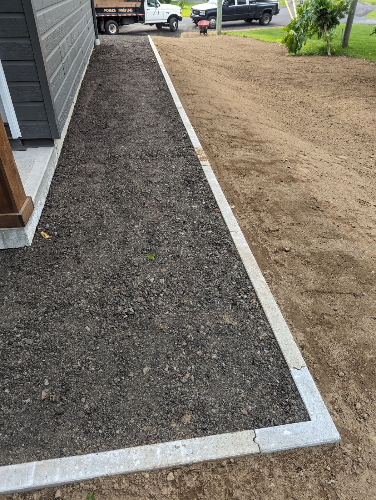 Un trottoir est en construction devant une maison.