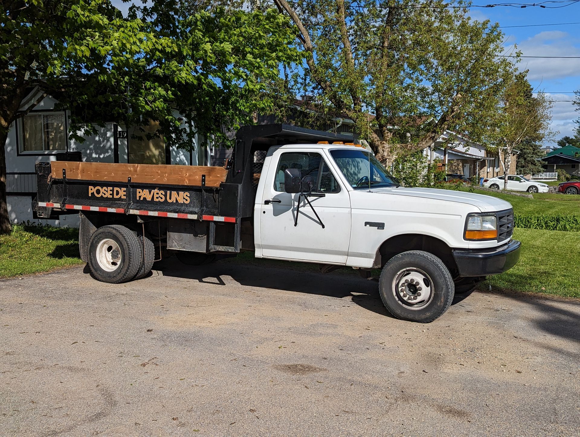 Un camion-benne blanc est garé dans un terrain de gravier.