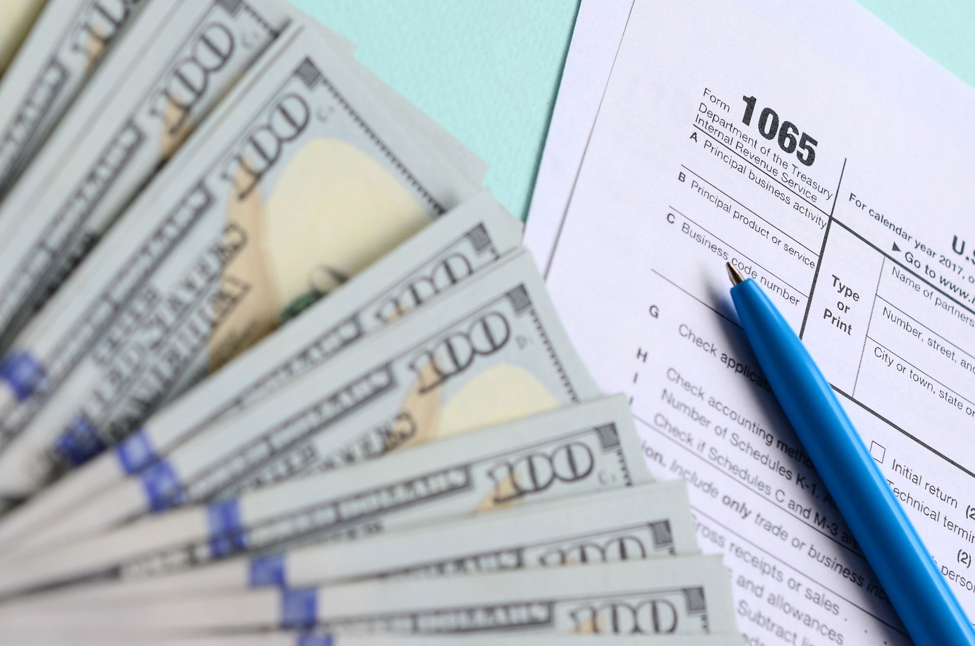 A stack of money is sitting on top of a tax form.