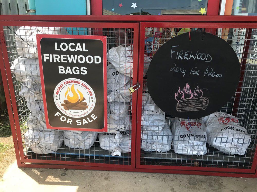A Red Cage Filled With Firewood Bags for Sale — West End Cash Store In Proserpine, QLD