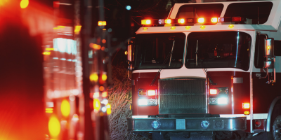 A fire truck is driving down a street at night.