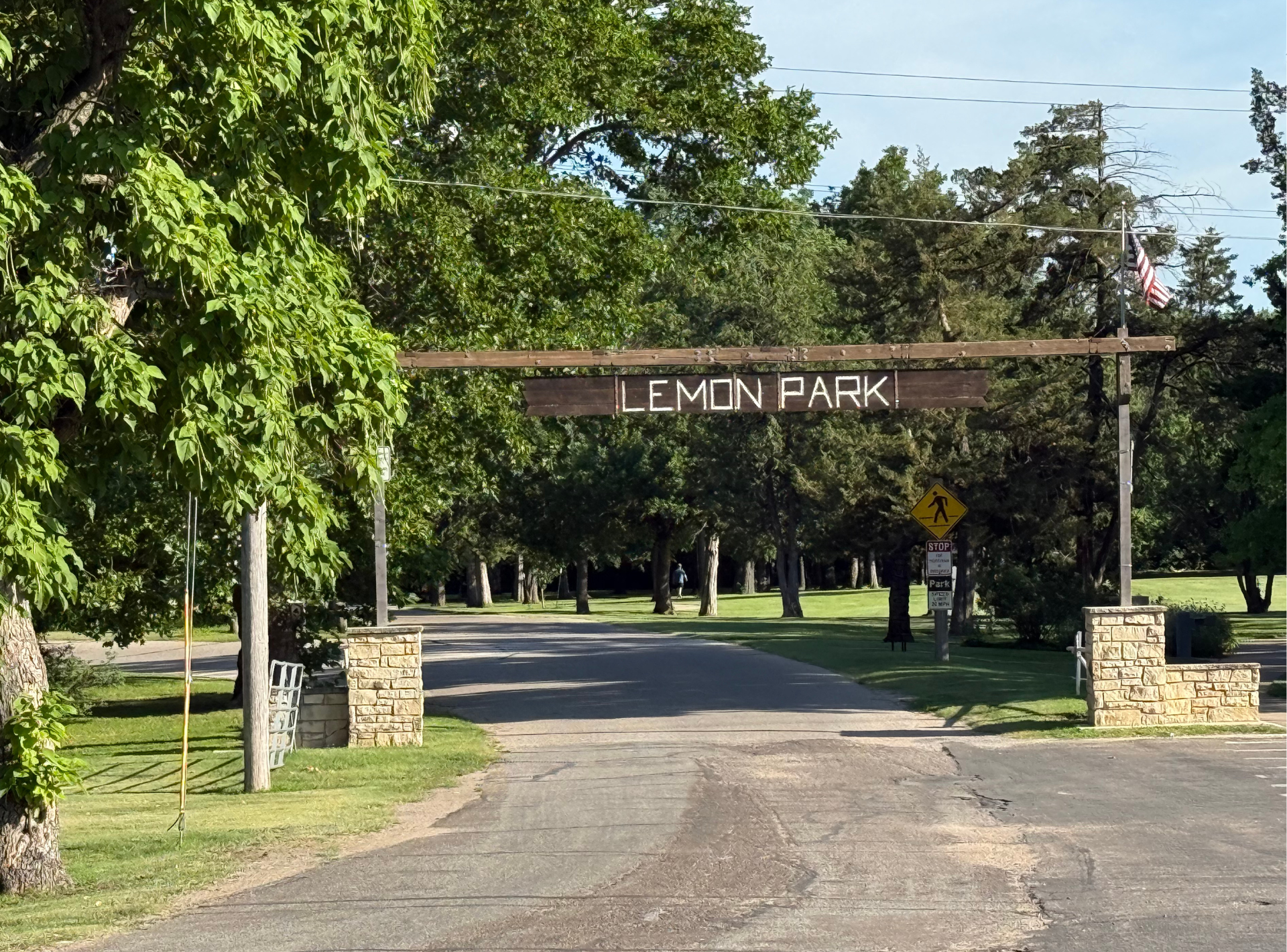 The entrance to lemon park is surrounded by trees and grass