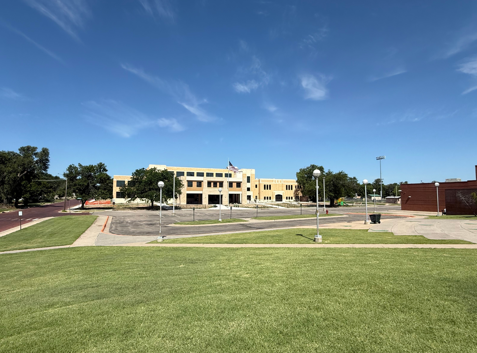 A large building is sitting in the middle of a lush green field.