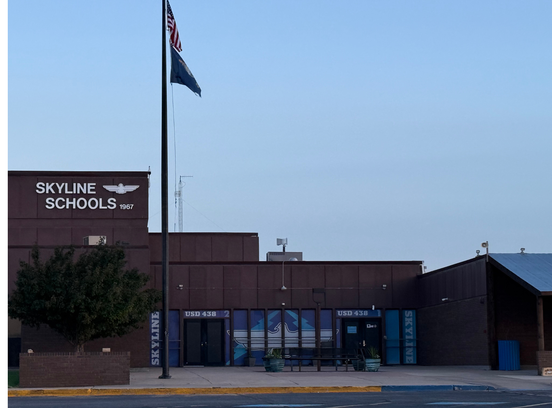 A skyline schools building with a flag in front of it