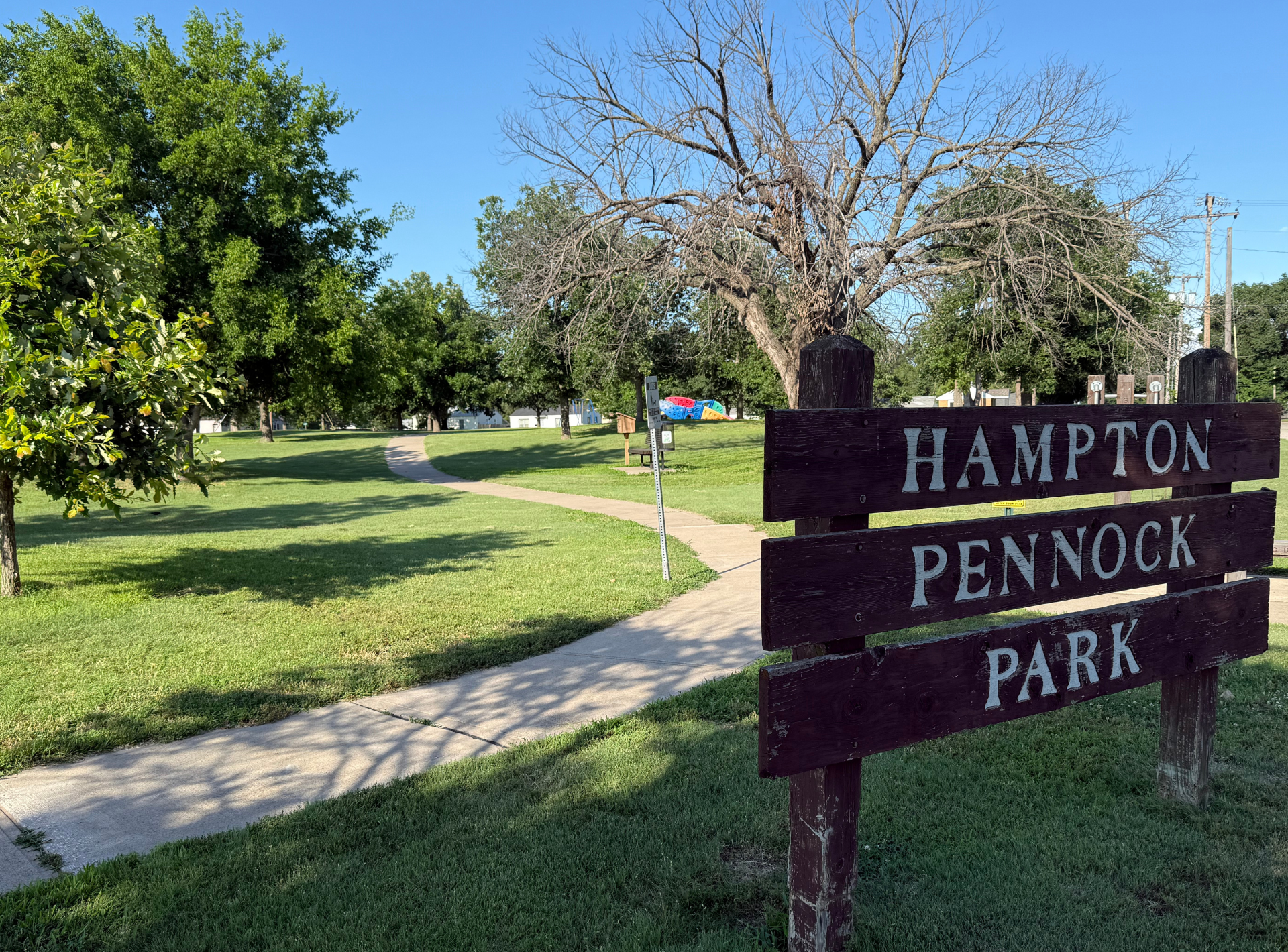 A wooden sign that says hampton pennock park on it