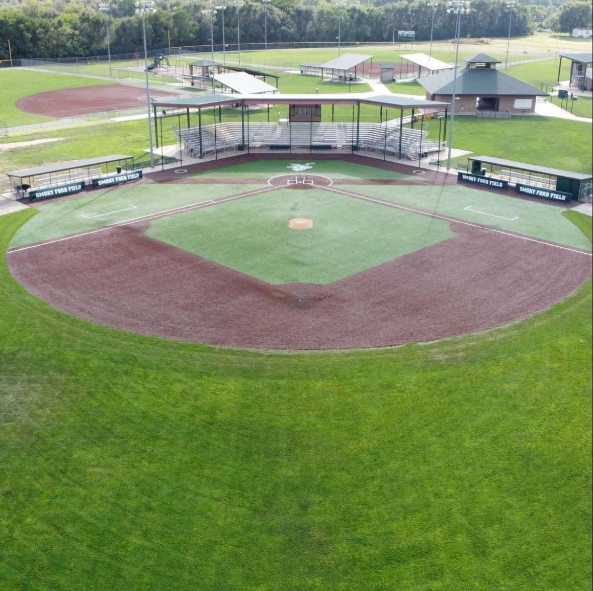 An aerial view of a baseball field with a stadium in the background