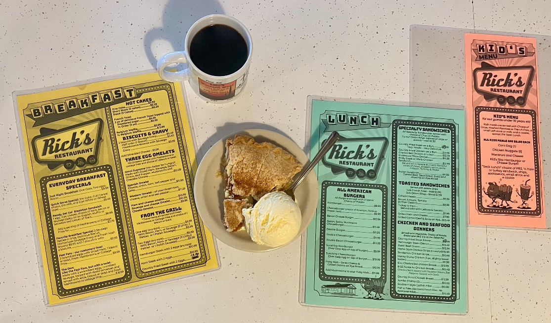 A rick 's menu is on a table next to a plate of food