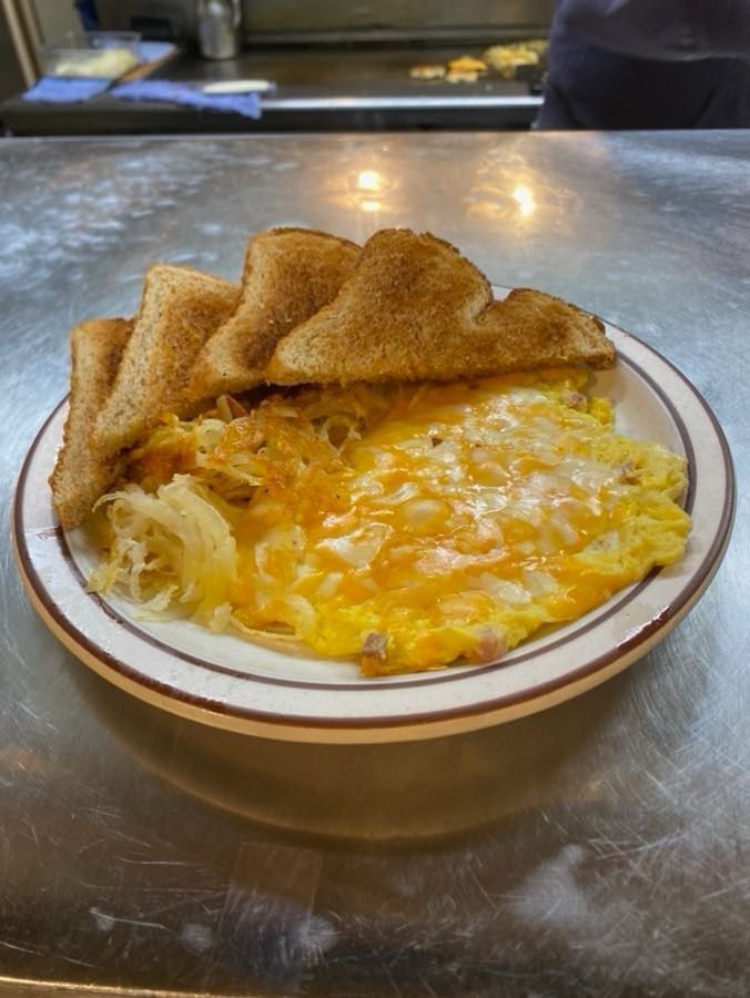 A plate of food with eggs , cheese and toast on a table.