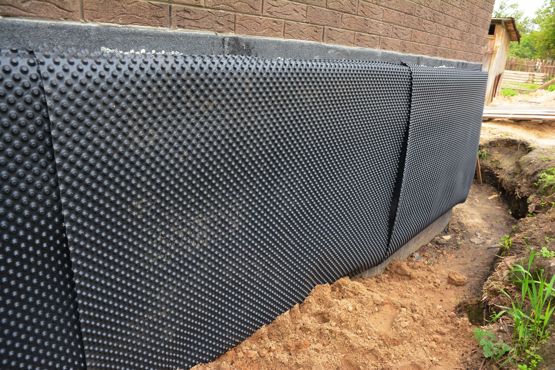 Installing a dimpled membrane, drainage sheet, and vapor barrier for home waterproofing