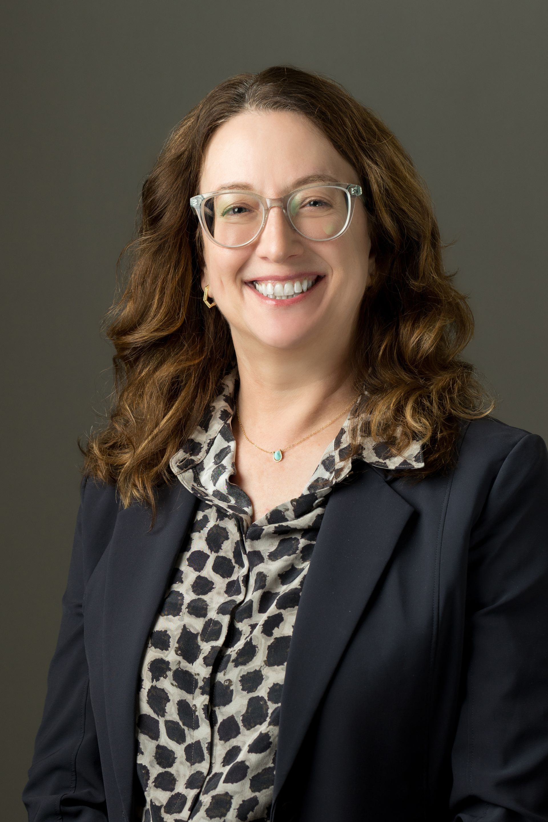 A family is walking through a field holding hands.
