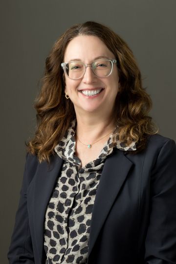 A family is walking through a field holding hands.
