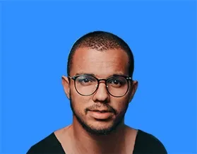 Man with glasses, short hair, and a goatee against a blue background.