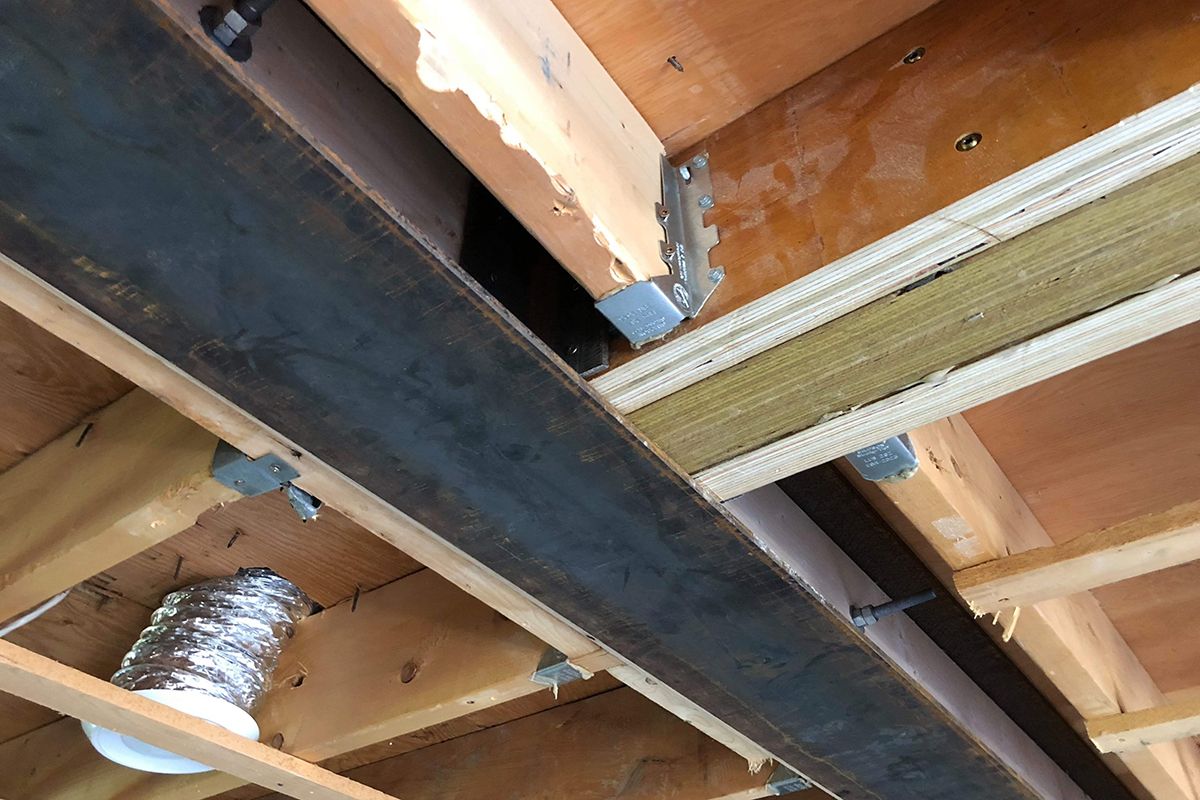 Un gros plan d'un plafond en bois avec une poutre en métal.