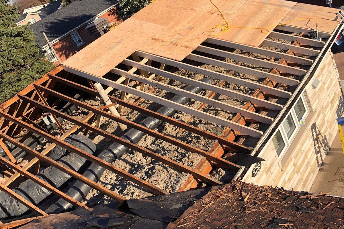 Le toit d'une maison est en train d'être construit avec des poutres en bois.