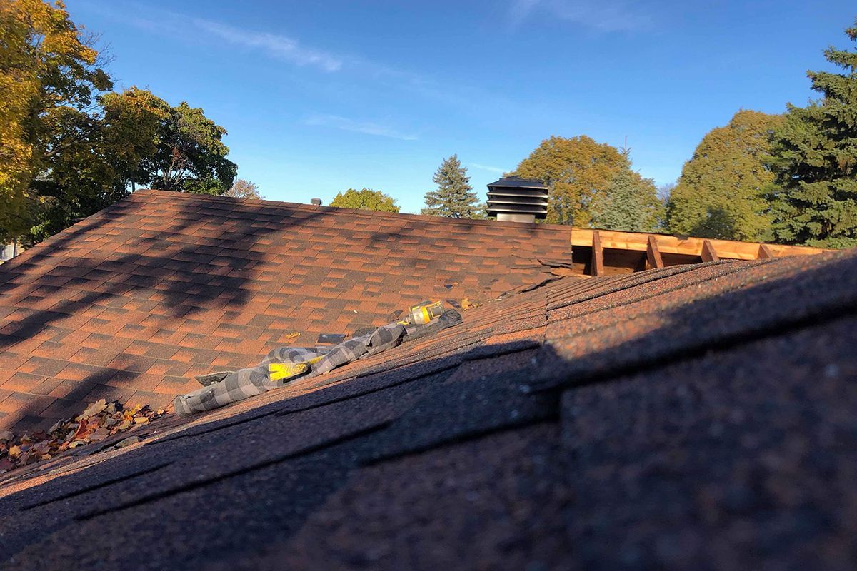 Un toit avec beaucoup de bardeaux et des arbres en arrière-plan.