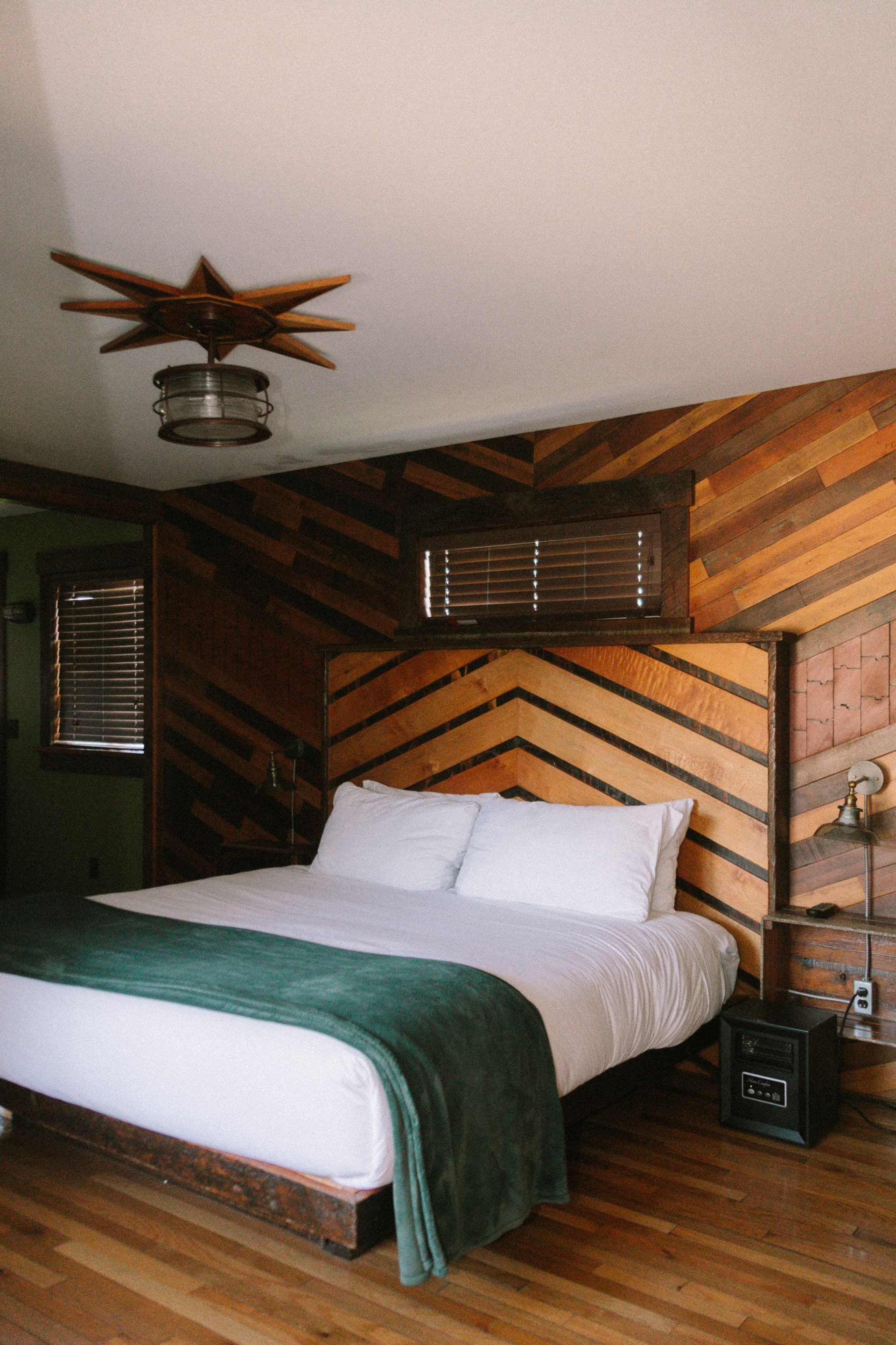 A bedroom with a bunk bed and a bed with white sheets.