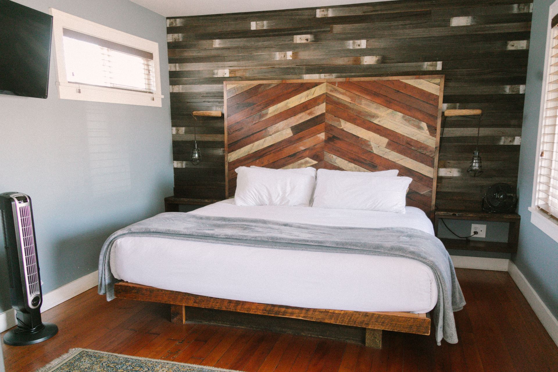 A hotel room with a king size bed and a flat screen tv.