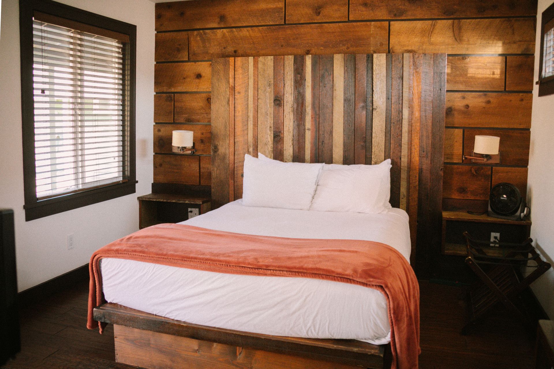 A bedroom with a bed and a wooden headboard.