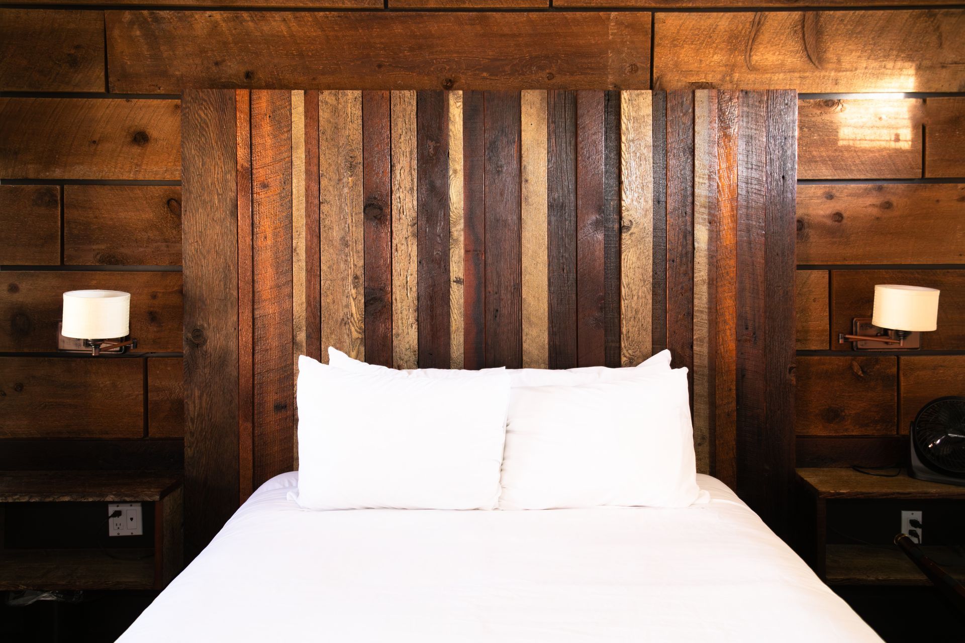 A bedroom with a bed and a wooden headboard.