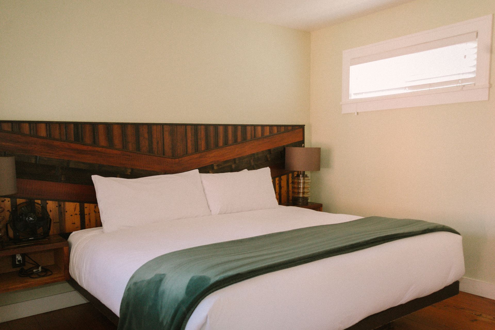 A bed with a wooden headboard and two lamps in a bedroom.