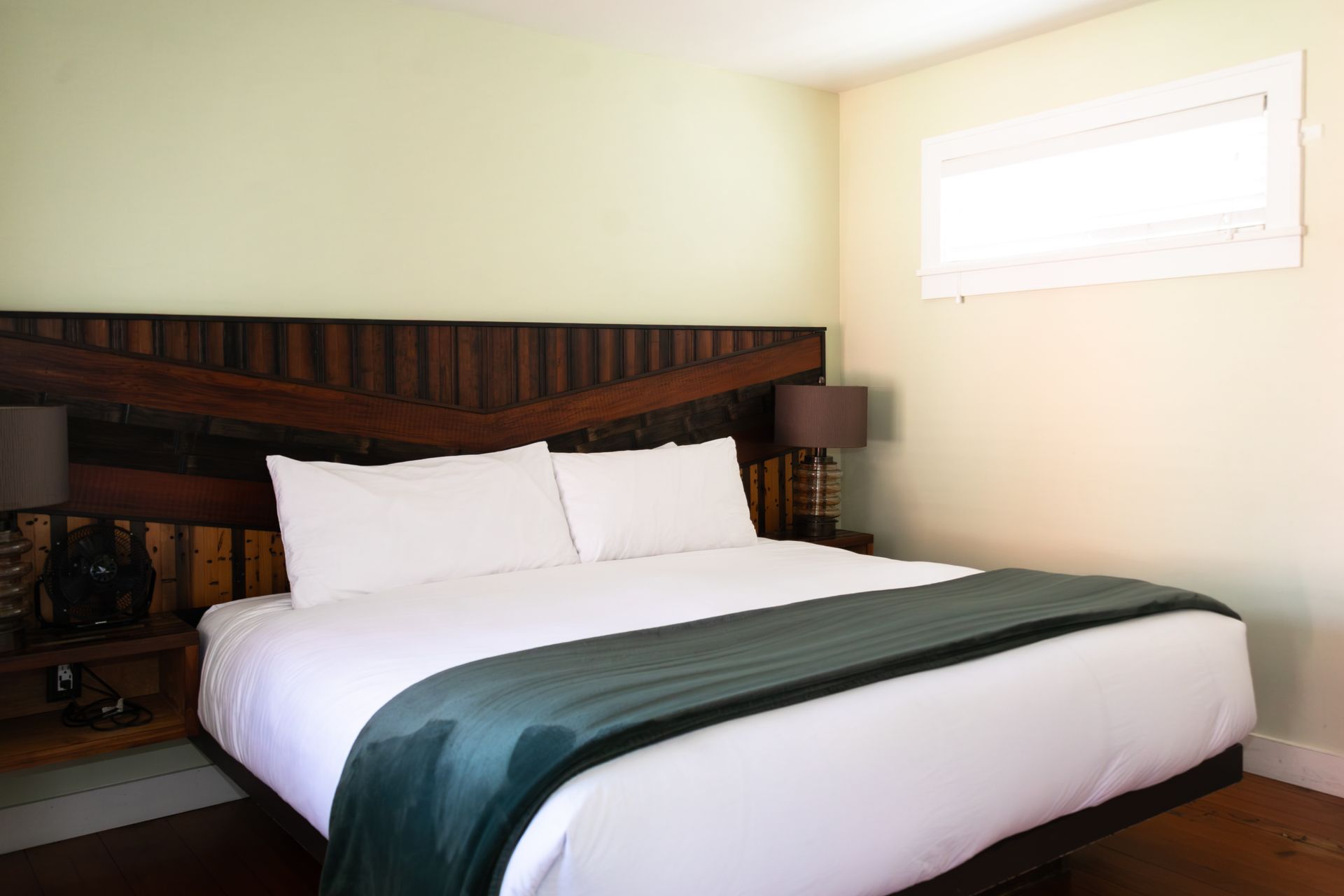A bed with a wooden headboard and two lamps in a bedroom.