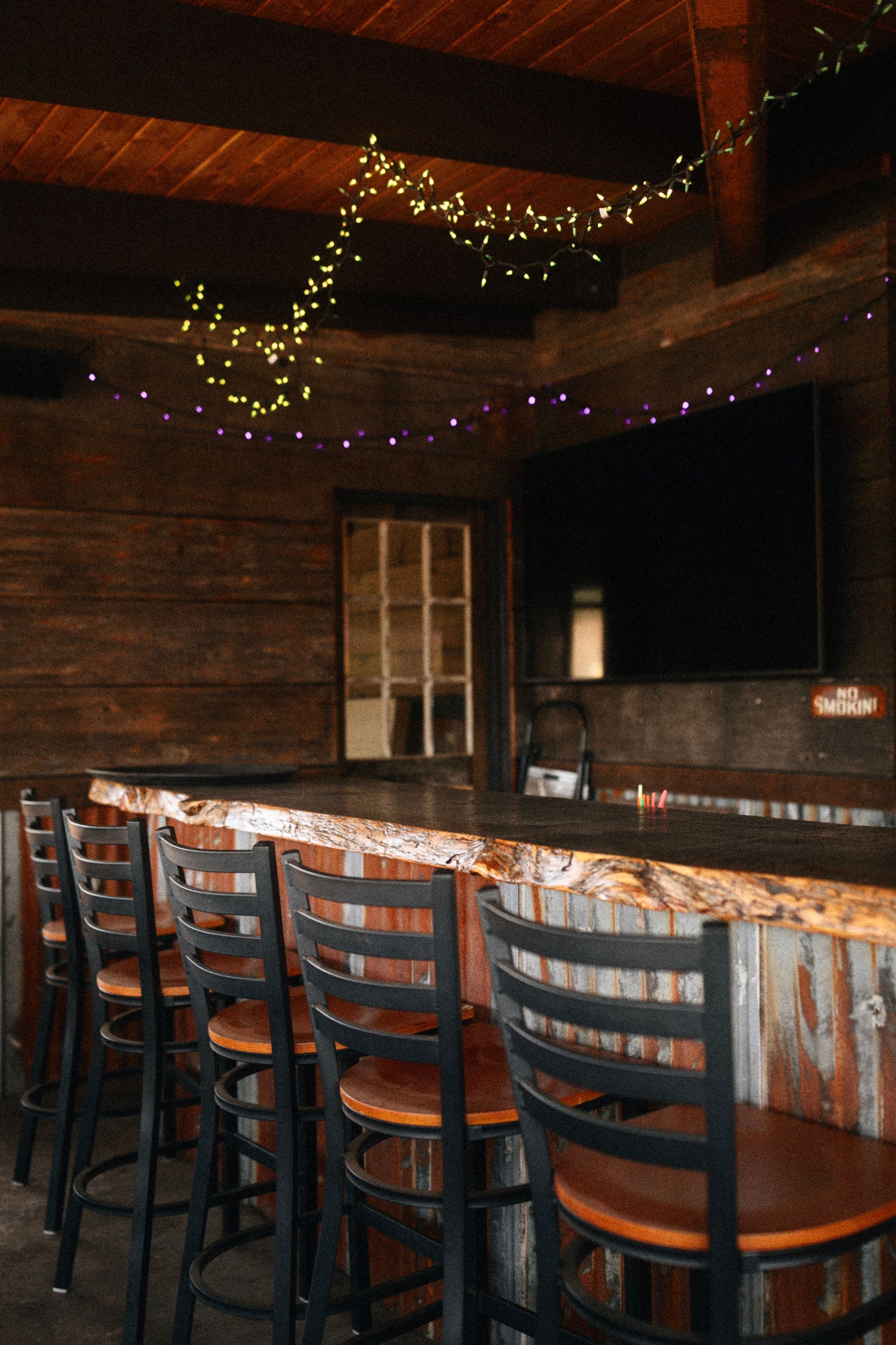 A group of people are sitting at a bar in a restaurant.