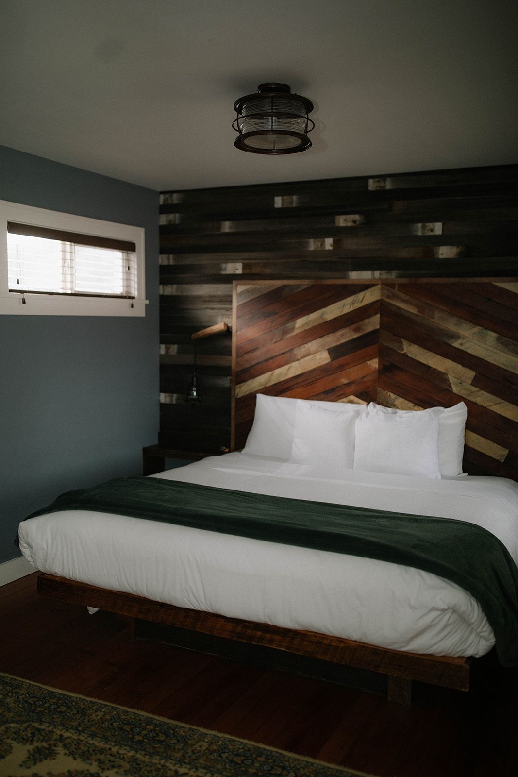 A bedroom with a large bed and a wooden headboard.