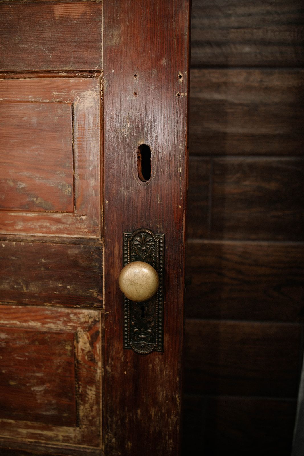 A close up of a door knob on a wooden door.