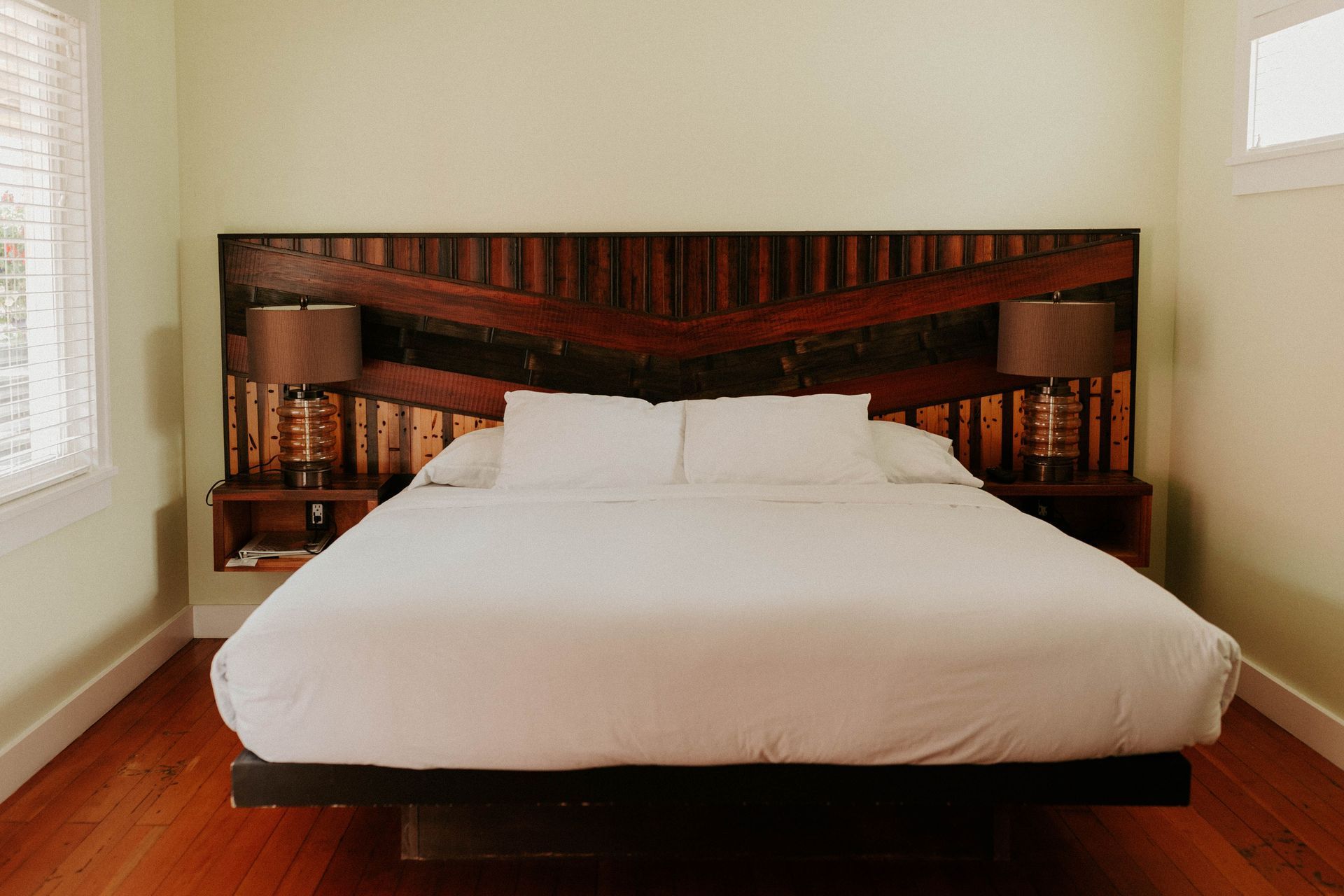 A bed with a wooden headboard and two lamps in a bedroom.