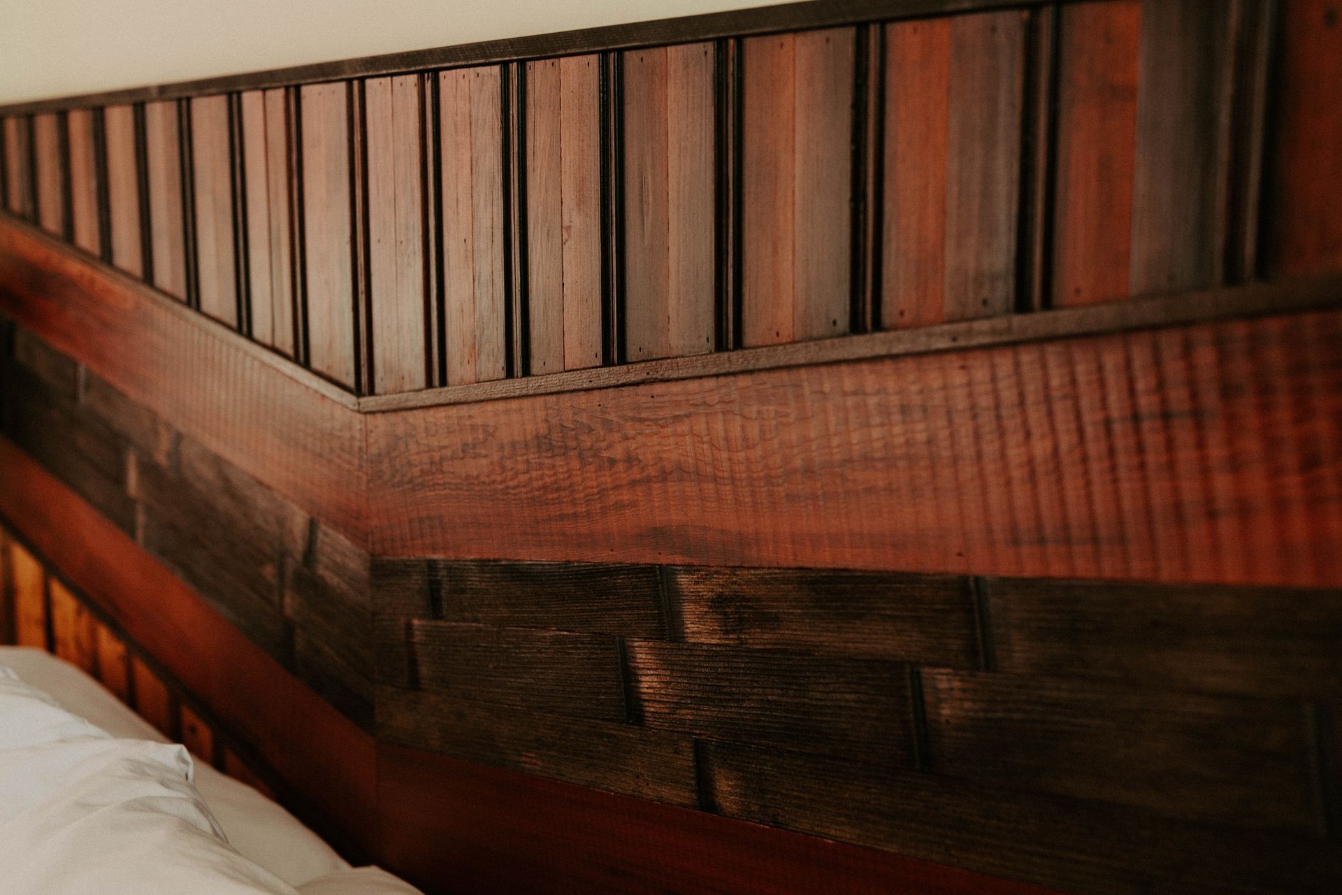 A close up of a wooden headboard on a bed.