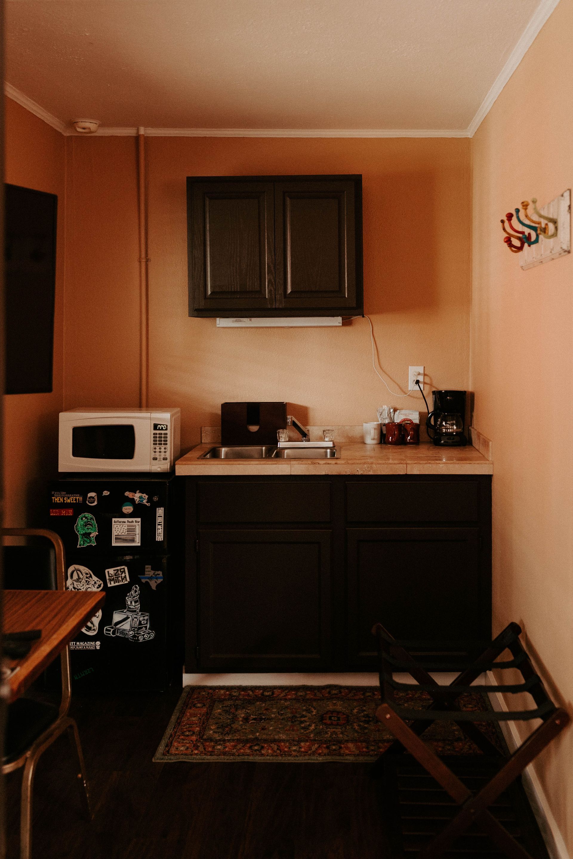 A small kitchen with a microwave , sink , and refrigerator.