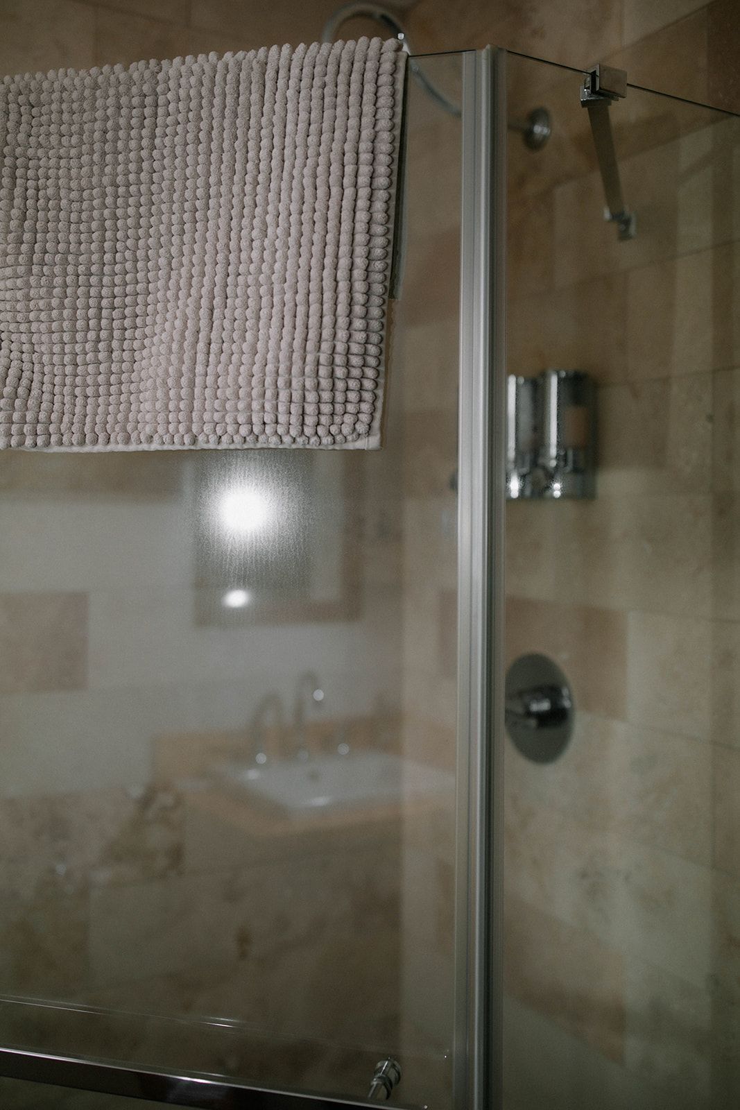 A bathroom with a shower and a towel hanging on the wall