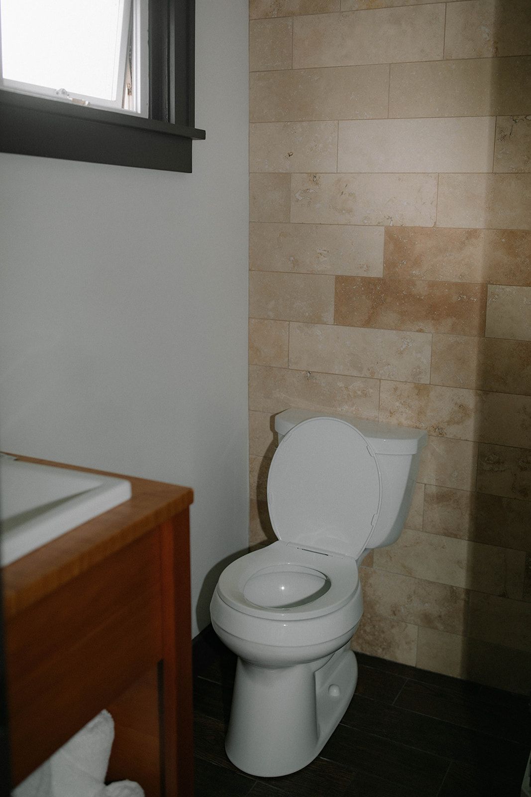 A bathroom with a toilet , sink and window