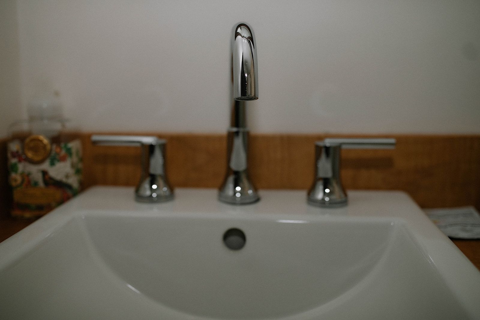 A bathroom sink with a chrome faucet and three handles