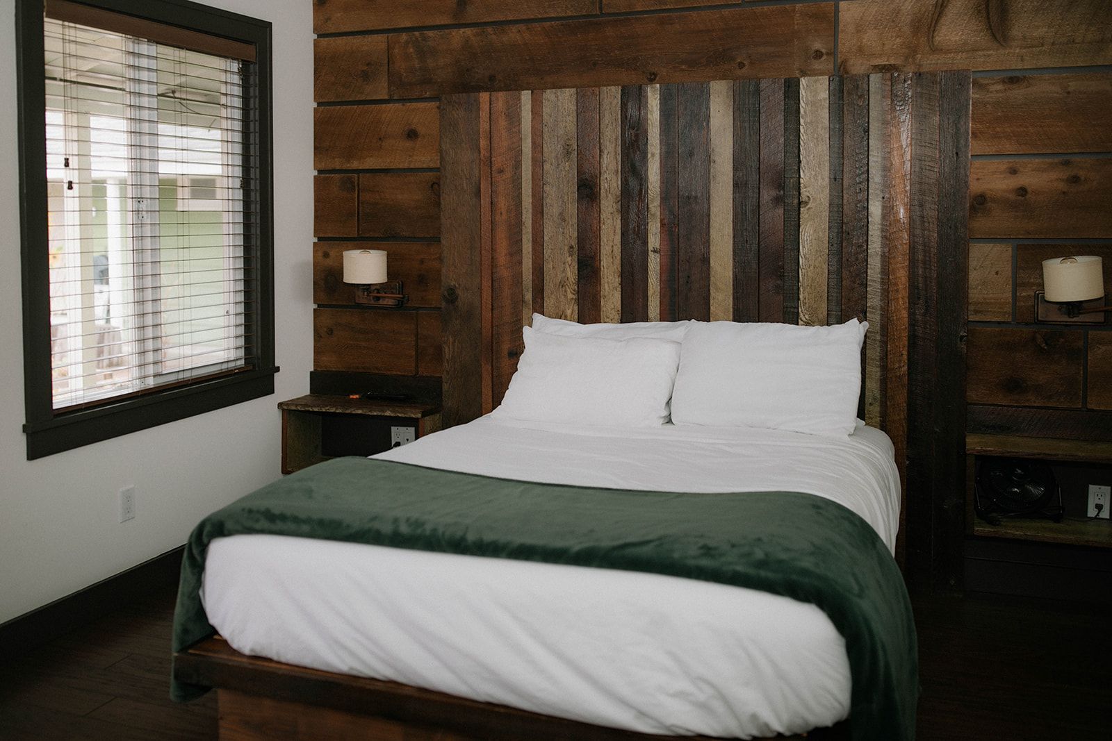 A bedroom with a bed and a wooden headboard.