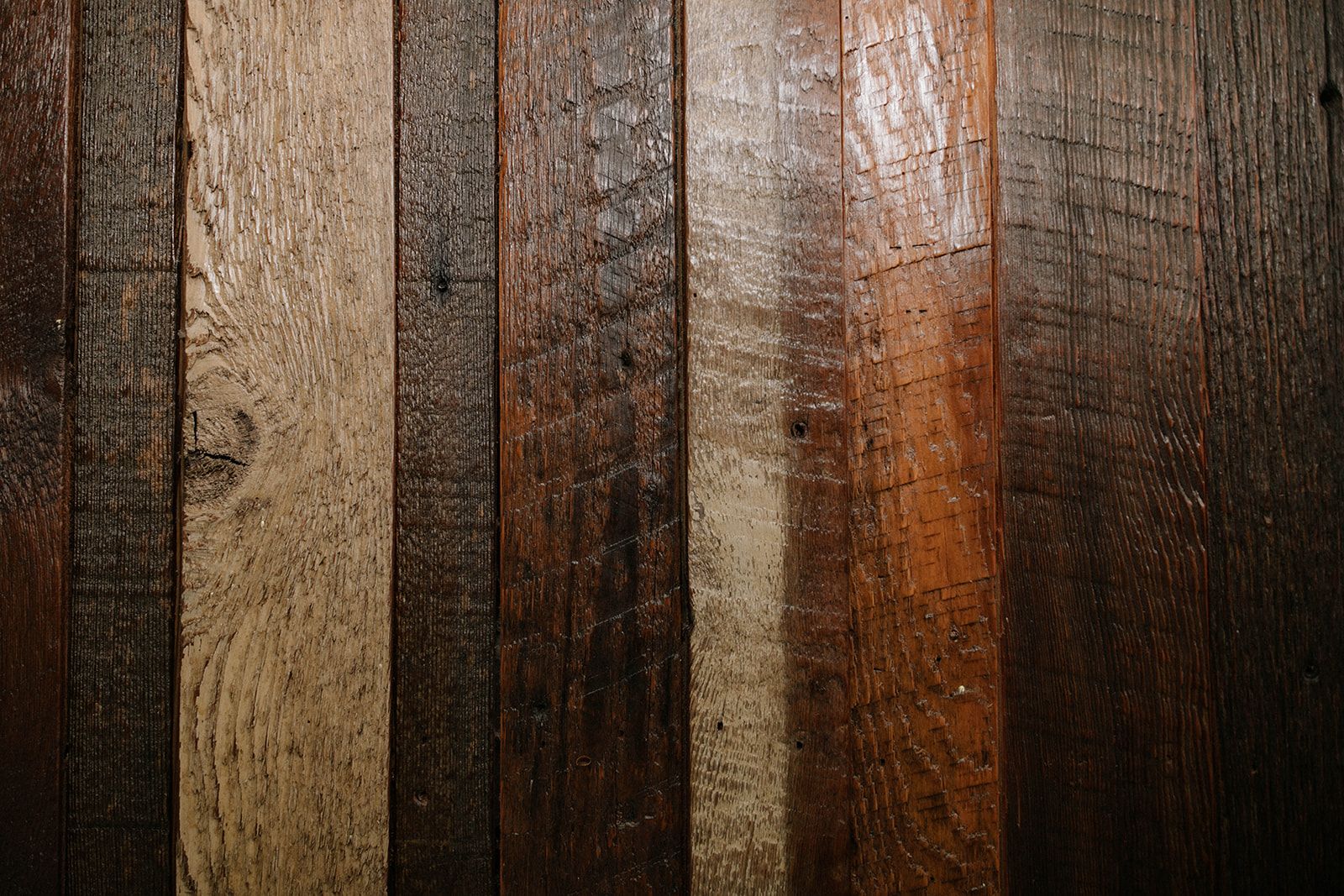 A close up of a wooden wall with different shades of wood.