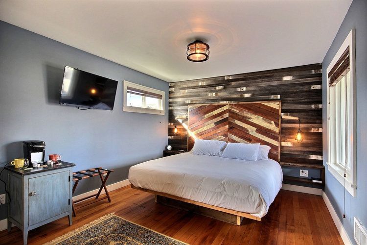 A hotel room with a king size bed and a flat screen tv.