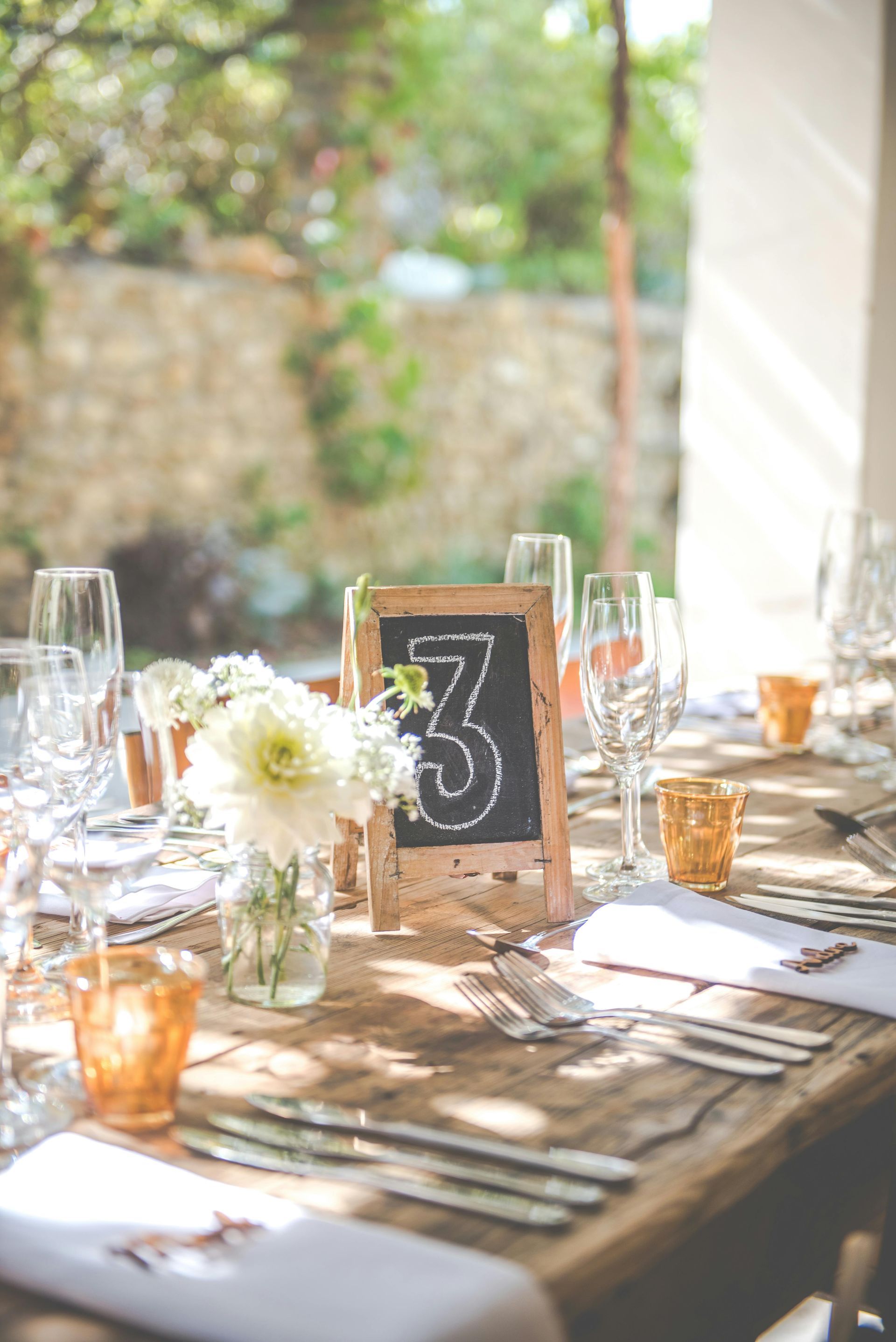 A table set for a wedding reception with a chalkboard table number.