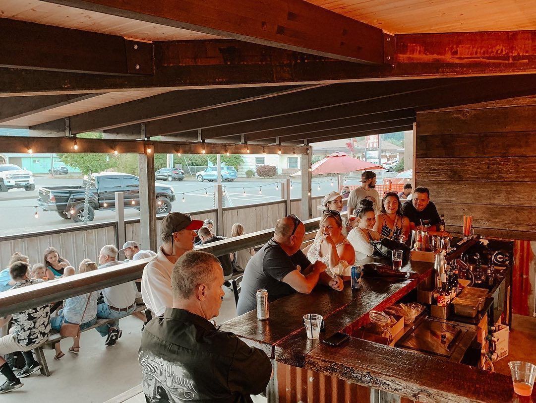 A group of people are sitting at a bar in a restaurant.