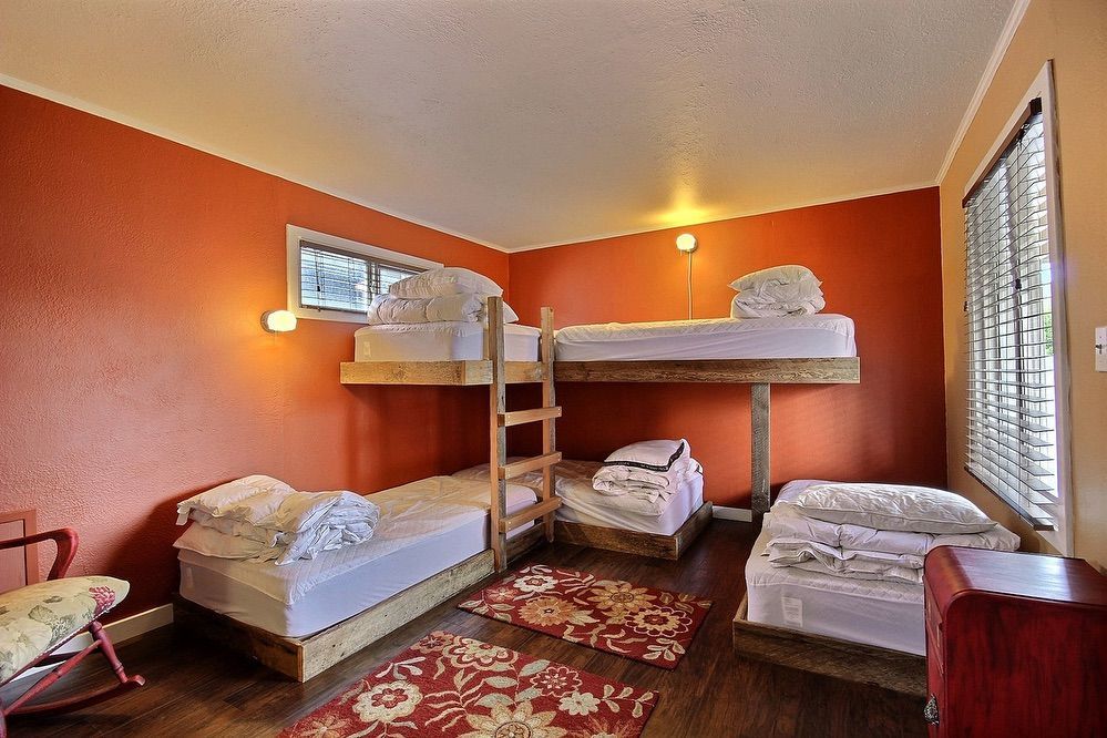 A room with four bunk beds and a rocking chair.